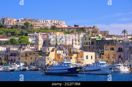 Panoramablick auf Procida, italienische Kulturhauptstadt 2022: Bunte Häuser, Cafés und Restaurants, Fischerboote in Marina Grande.in Bucht von Neapel. Stockfoto