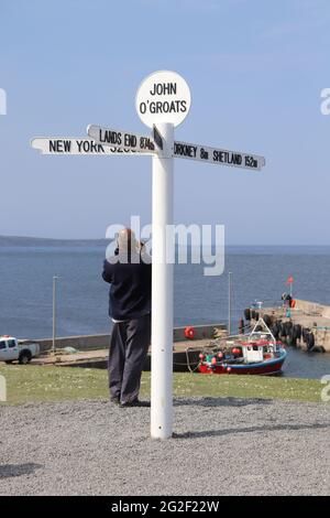 Berühmter Wegweiser in John O'Groats am nördlichsten Punkt des schottischen Festlandes, der die Entfernungen nach New York, Land's End und Edinburgh anzeigt Stockfoto