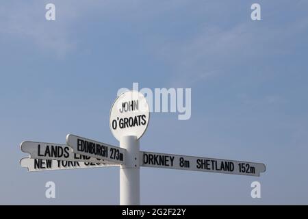 Berühmter Wegweiser in John O'Groats am nördlichsten Punkt des schottischen Festlandes, der Entfernungen nach New York, Land's End, Edinburgh und Orkney anzeigt Stockfoto