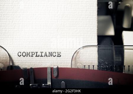 Das Wort Compliance mit einer Schreibmaschine geschrieben. Stockfoto