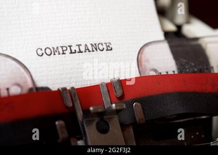 Das Wort Compliance mit einer Schreibmaschine geschrieben. Stockfoto