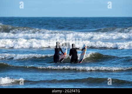 TOFINO, KANADA - 10. Juni 2021: Surfer auf dem Weg zum Meer, Tofino, BC Kanada Stockfoto
