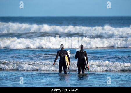 TOFINO, KANADA - 10. Juni 2021: Surfer auf dem Weg zum Pazifik, Tofino, BC Kanada Stockfoto