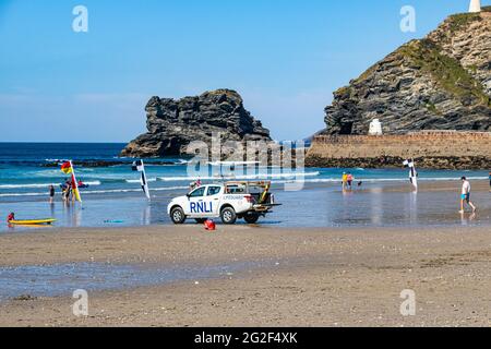 Keeping You Beach Safe - RNLI Rettungswagen am Portreath Beach, Cornwall mit Hafenmauer, Blick auf Hütte und Küste Detail im Frühsommer. Stockfoto