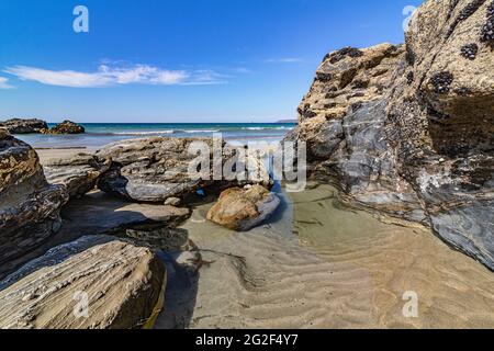 Low Tide – Detail der Felsen, Pool und Meerblick am Strand von Portreath mit blauem Himmel im Frühsommer. Stockfoto