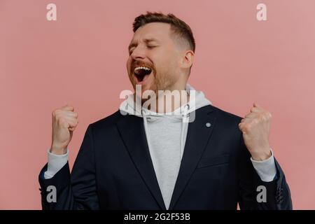 Glücklich aufgeregt Mann mit geschlossenen Augen Heben geballte Fäuste und den Sieg zu feiern Stockfoto