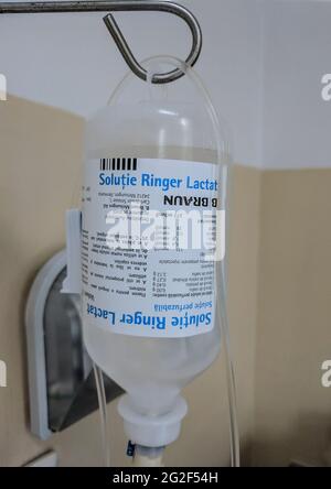 Flasche mit Kochsalzlösung, die an einem Metallpol in einem rumänischen Krankenhaus aufgehängt wird. 23. April 2019, Bukarest, Colentina Hospital Stockfoto