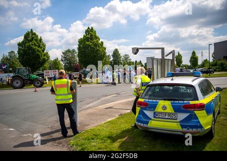 Edewecht, Deutschland. Juni 2021. Polizeibeamte stehen neben einer Protestaktion von Milchbauern, die vor dem DKM Deutsches Milchkontor für angemessene Milchpreise demonstrieren. Angesichts der extrem gestiegenen Kosten für Futter und Energie bei nur moderat steigenden Milchpreisen ruft die Arbeitsgemeinschaft bäuerliche Landwirtschaft (ABl) zu einem Protest unter dem Motto "No more fun - no more walls" auf. Quelle: Sina Schuldt/dpa/Alamy Live News Stockfoto