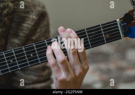 Der Musiker spielt Gitarre. Finger auf einem Griffbrett der Gitarre aus nächster Nähe Stockfoto