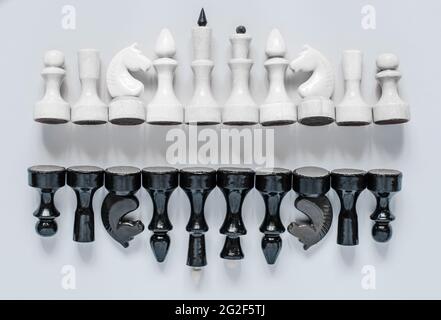 Schwarz-weiße Schachfiguren sind in einer Reihe gestapelt, Draufsicht Stockfoto