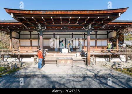 Kyoto, Japan - 2017.12.01: Menschen betreten einen kleinen alten buddhistischen Tempel im Arashiyama-Viertel Stockfoto