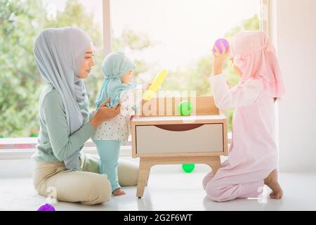 Muslimische arabische Familie Mutter und ihre Kinder glücklich spielen zusammen zu Hause niedlich und schön. Stockfoto