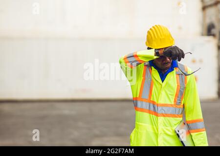 Müde Stress Arbeiter Schweiß von heißem Wetter im Sommer arbeiten in Port Goods Fracht logistischen Boden, schwarz afrikanischen Rasse Menschen. Stockfoto