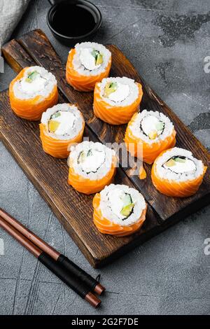 Sushi-Rolle, Philadelphia mit Lachs, geräuchertem Aal, Avocado, Frischkäse-Set, Auf grauem Steingrund Stockfoto