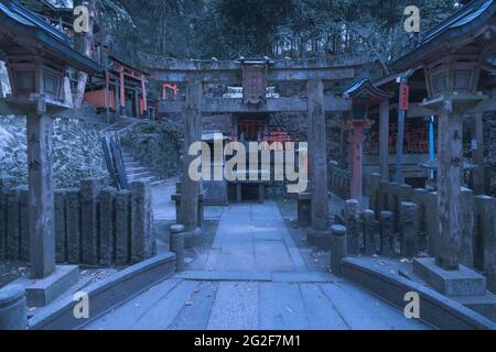 Kyoto, Japan - 05.19.2019: Einer von vielen Teilen des berühmten Fushimi Inari-Schreines nach der Dämmerung. Steintorientore und Steinaltar Stockfoto