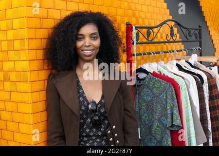 Großbritannien / England /London / wunderschöne Frau, die beim Classic Car Boot Sale am Granary Square in King's Cross London Vintage-Kleidung verkauft. Stockfoto