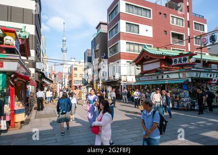 Tokio, Japan - 05.13.2019: Tokyo Sky Tree an einem sonnigen Tag mit vielen Menschen von der Straße zum Asakusa-Tempel aus gesehen Stockfoto