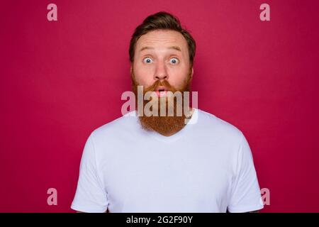 Wunderte sich über einen isolierten Mann mit Bart und weißem T-Shirt Stockfoto