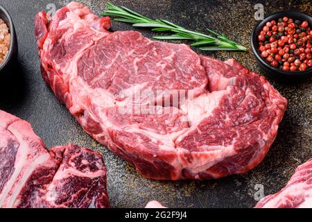 Rib Eye Beef Steak roh, auf altem dunklen rustikalen Hintergrund Stockfoto