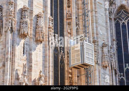 Mailand, Italien - 7. Juli 2020. Restaurierungsarbeiten in der Mailänder Kathedrale, Duomo di Milano, Arbeiter mit mechanischem Aufzug. Duomo Kathedrale Gebäude während Stockfoto