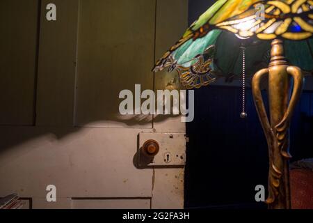 Eine Jugendstil-Lampe mit Tiffany-Lampenschirm aus Buntglas, der wunderschöne Schatten erzeugt. --- EIN Wochenende im Brooklyn House, Martham Stockfoto