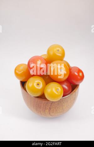 Rote und gelbe Kirschtomate in einer Schüssel auf weißem Hintergrund Stockfoto
