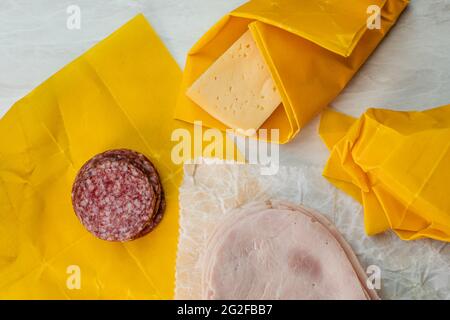 Käse-, Salami- und Schinkenscheiben in Bienenwachspapier verpackt Stockfoto