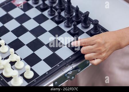 Mit einem Stück in einer Hand auf dem Schachbrett hochwertige Foto Stockfoto