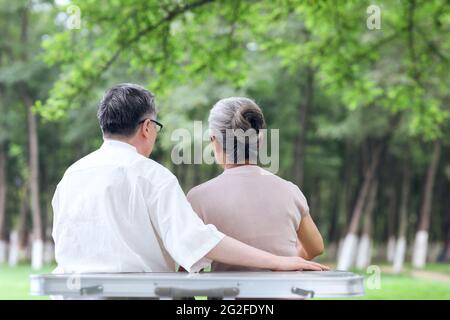 Glückliches altes Paar sitzt auf Stühlen im Outdoor-Park hochwertige Foto Stockfoto
