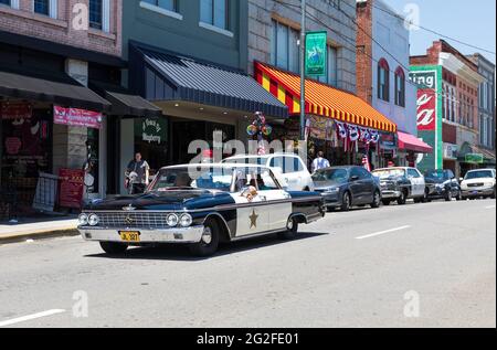MT. AIRY, NC, USA-5 JUNE 2021: Ein 60s Ford Galaxie Police Car fährt die Main Street entlang, was an Andy Griffiths Fahrt in einer beliebten TV-Show erinnert. Peopl Stockfoto