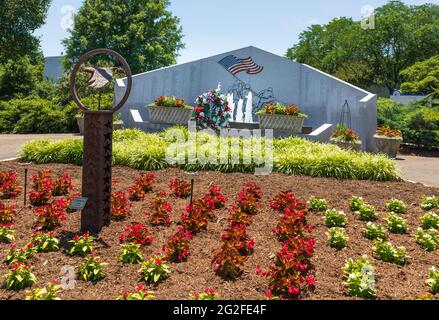 MT. AIRY, North Carolina, USA-5 JUNE 2021: Ein Denkmal aus Granit für Männer und Frauen aus der Region, die in Kriegen des 20. Jahrhunderts verloren wurden. Blumenbeet im Vordergrund. Horizontales Bild Stockfoto
