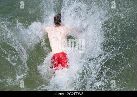 Dresden, Deutschland. Juni 2021. Ein Schwimmer springt im Mockritz-Naturbad ins Wasser. Die Freiluft-Badesaison wurde aufgrund von Corona mit einer Verzögerung im Freistaat eröffnet. Quelle: Sebastian Kahnert/dpa-Zentralbild/dpa/Alamy Live News Stockfoto