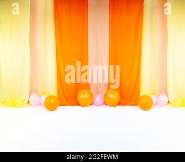 Eleganter Hintergrund mit Samtrollen aus Stoff und Luftballons für Studiofotos Stockfoto