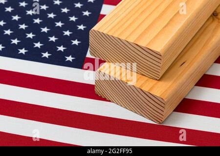 Weichholz Bauholz auf der Flagge der Vereinigten Staaten von Amerika. Konzept von Handelskrieg, Zöllen, fairem Handel und Holz, Holzwirtschaft Stockfoto