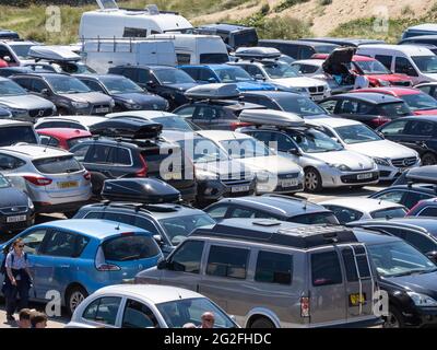 Parkplatz am Strand voller Autos während der Sommerferien, Bude, Cornwall, Großbritannien Stockfoto