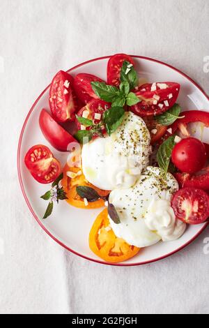 Pochiertes Ei und frische Tomaten mit Basilikum und Mayonnaise, Draufsicht. Stockfoto