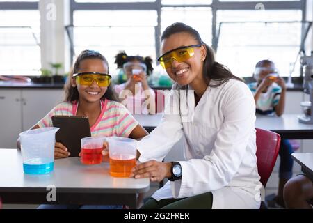 Porträt einer afroamerikanischen Lehrerin und eines lächelnden Mädchens während des wissenschaftlichen Unterrichts im Labor Stockfoto