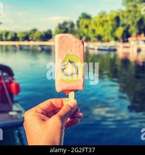 Essen Selfie Mädchen hält Eis Pop im Sommerpark. Gefiltert für das Teilen von Smartphone-Apps in sozialen Medien Stockfoto