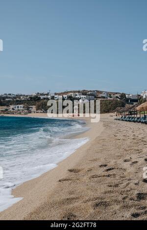 Kalafati, Griechenland - 23. September 2019: An einem sonnigen Sommertag waschen sich die Wellen am Strand von Kalafati, einem beliebten Strand auf Mykonos, der für Wassersport bekannt ist. Stockfoto