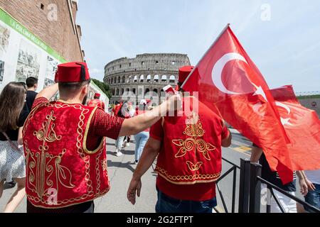 Rom, Italien. Juni 2021. Die Freunde Alpagan (l) und Boylu gehen in Richtung Kolosseum in Romee mit ihren Nationalflaggen der Türkei. Die beiden Freunde Frome Stuttgart haben Tickets für das Eröffnungsspiel der Türkei gegen Italien und sind für das Spiel nach Romee gereist. Die Fußball-Europameisterschaft beginnt am 11. Juni in Romee mit dem Eröffnungsspiel zwischen der Türkei und Italien. Quelle: Matthias Balk/dpa/Alamy Live News Stockfoto