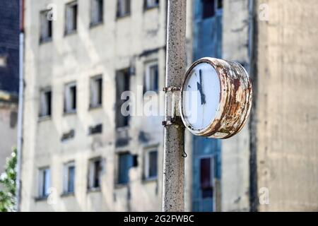 Pasewalk, Deutschland. Juni 2021. Eine verwitterte Uhr auf dem Gelände eines ehemaligen DDR-Agrarunternehmens vor einem baufälligen Gebäude. Bis zum Mauerfall war hier eine konzentrierte Futtermischanlage der VEB Getreidewirtschaft Pasewalk. Die Uhr hörte kurz vor 11 Uhr auf. Quelle: Jens Kalaene/dpa-Zentralbild/ZB/dpa/Alamy Live News Stockfoto