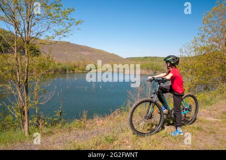 Junge auf dem Mountainbike, ‘Carrière Barrois’ Steinbruch mit seinen großen roten Sandsteinfelsen und Teich, Wardnt Wald, Freyming-Merlebach, Moselle (57), Grand Stockfoto