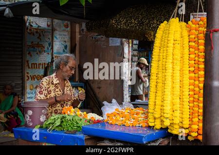 Ein nicht identifizierter indischer Verkäufer, der am 2020. Oktober auf dem lokalen Markt in Kalkutta, Indien, bunte Blumen auf seinem Wagen verkauft Stockfoto
