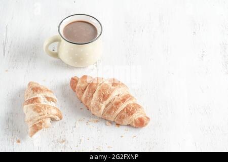 Closeup knusprige Croissants und eine Tasse Kaffee auf einem Holztisch mit Platz zum Kopieren Stockfoto