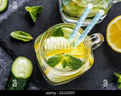 Über Ansicht von zwei Einmachglas mit Detox Wasser auf dunklen konkreten Hintergrund. Sommer-Getränk mit Gurke, Zitrone und Minze. Kopieren Sie Raum. Draufsicht oder flach legen Stockfoto