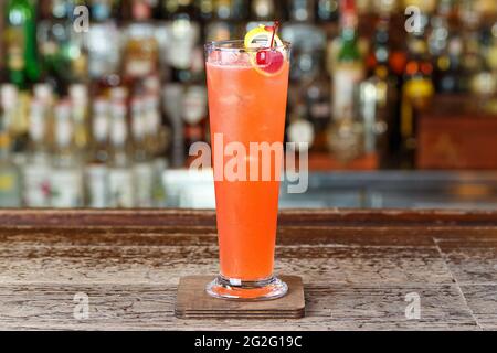 Erdbeer-Club-Cocktail auf der Basis von Gin, dekoriert mit Kirschen und Zitronenschale. Platz für Textgestaltung Stockfoto