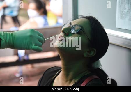 Guwahati, Guwahati, Indien. Juni 2021. Eine Gesundheitsarbeiterin nimmt am Freitag, den 11. Juni 2021, einen Nasenabstrich einer Journalistin für den COVID-19-Test im Presseclub Guwahati in Guwahati Assam India.Quelle: Dasarath Deka/ZUMA Wire/Alamy Live News Stockfoto