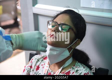 Guwahati, Guwahati, Indien. Juni 2021. Eine Gesundheitsarbeiterin nimmt am Freitag, den 11. Juni 2021, einen Nasenabstrich einer Journalistin für den COVID-19-Test im Presseclub Guwahati in Guwahati Assam India.Quelle: Dasarath Deka/ZUMA Wire/Alamy Live News Stockfoto