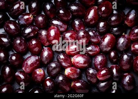 Hintergrund aus roten Trauben mit Wassertropfen. Stockfoto
