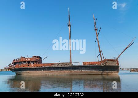 Auf einem der Seen in Ontario, auf dem Dock, lebt ein rostiges Dreimast-Schiff seine letzten Tage. Stockfoto